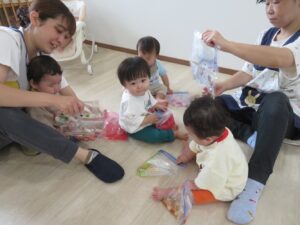 スタッフと入居者が床で色彩活動やレクリエーションを行っている風景